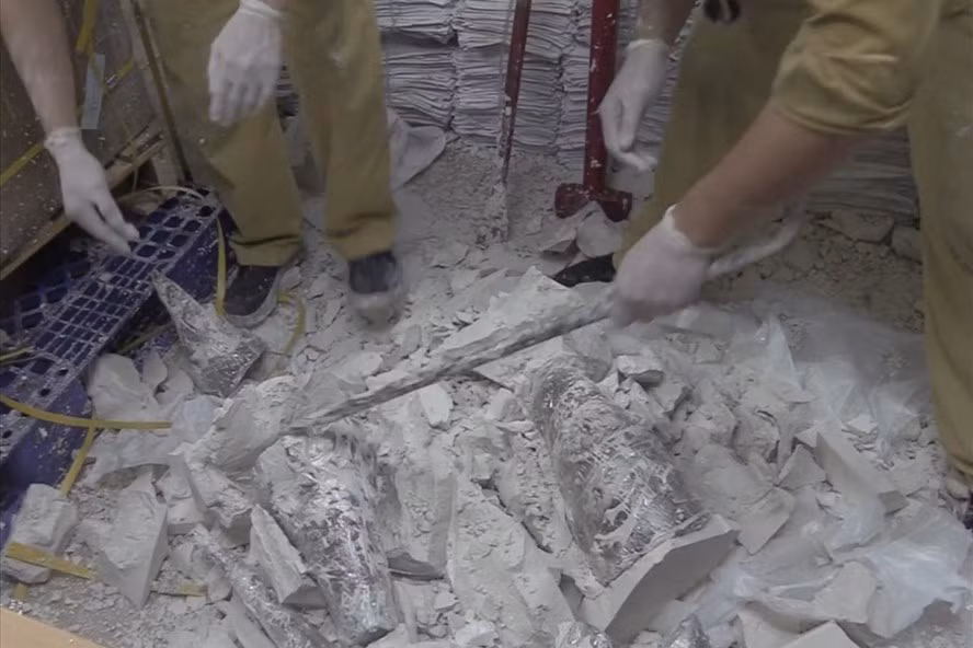 Lực lượng chức năng phải dùng dụng cụ chuyên dụng để đập phá thạch cao, lấy ra những khúc sừng tê giác. Ảnh: H.Q. Lực lượng chức năng phải dùng dụng cụ chuyên dụng để đập phá thạch cao, lấy ra những khúc sừng tê giác. Ảnh: H.Q.