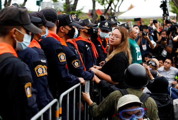 Một lãnh đạo biểu tình đưa lá thư có các yêu sách cho cảnh sát - Ảnh: REUTERS