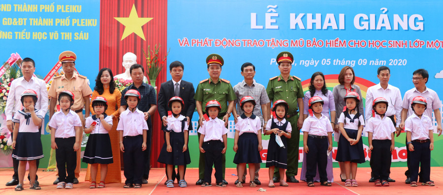 Lãnh đạo Ban An toàn Giao thông tỉnh, UBND TP. Pleiku và đại diện các cơ quan trao tặng mũ bảo hiểm cho học sinh lớp 1 Trường Tiểu học Võ Thị Sáu (TP. Pleiku). Ảnh: Lê Hòa