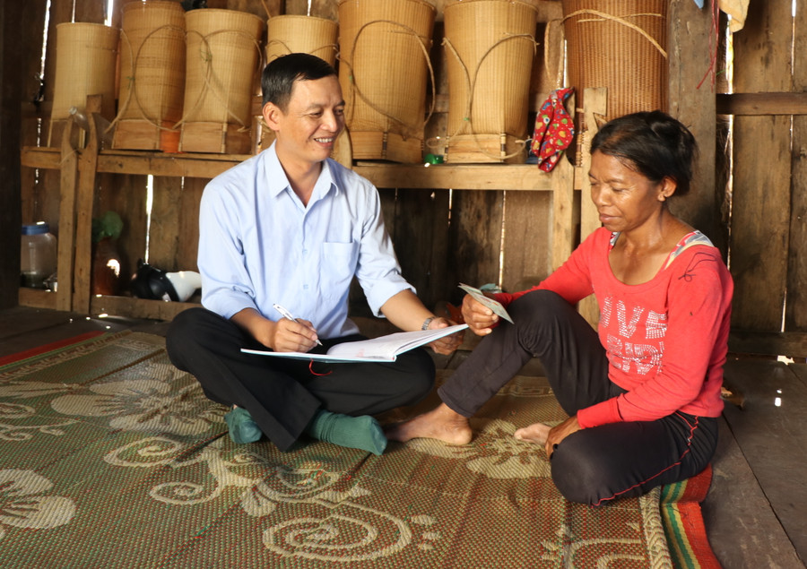 Anh Lê Hữu Hiền (bên trái), công chức Tư pháp-Hộ tịch (xã Yang Bắc, huyện Đak Pơ) đến tận nhà người dân tuyên truyền, hướng dẫn người dân làm các thủ tục, giấy tờ. Ảnh Ngọc Minh.JPG