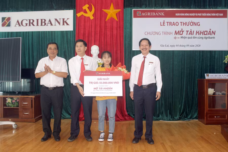 Lãnh đạo Ngân hàng Nhà nước tỉnh, Agribank Đông Gia Lai trao thưởng giải Nhất cho khách hàng Lê Hiền Lương. Ảnh: Sơn Ca
