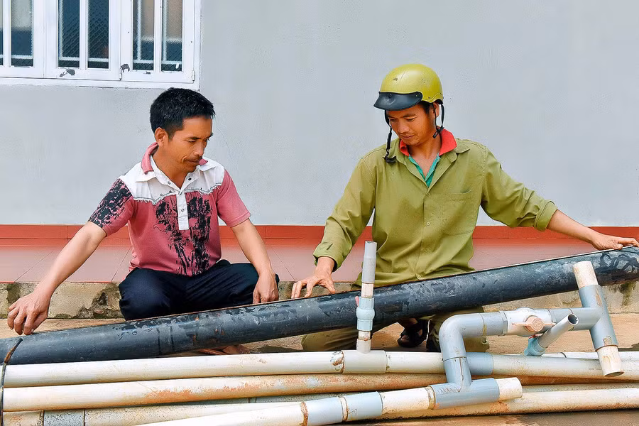 6. Gia đình anh Nhim (bìa phải; làng Đê Kốp, thị trấn Kon Dơng) trước đây thuộc diện hộ cận nghèo. Khi được vay 20 triệu đồng của Phòng Giao dịch Ngân hàng CSXH huyện, anh đã đầu tư mua ống nước tưới và cải tạo vườn cà phê già cỗi. Đến nay, gia đình anh đã thoát khỏi diện hộ cận nghèo và có nguồn thu nhập ổn định.