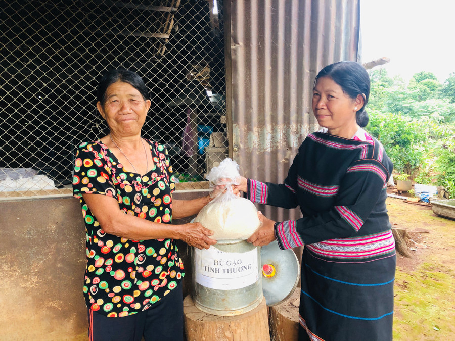 Bà Siu Búi (bìa phải) tặng gạo cho bà Kpă Ken. Ảnh: Thủy Bình
