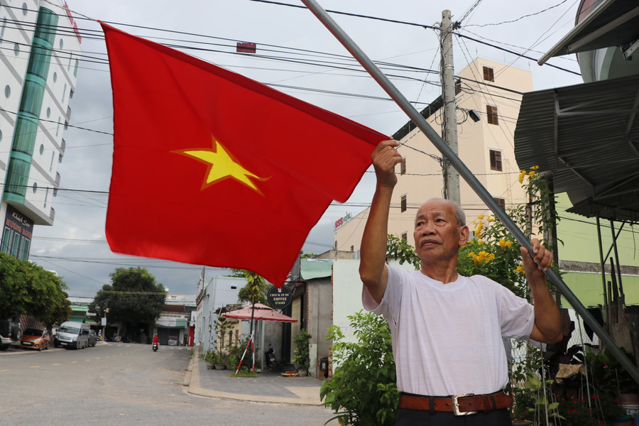 Ông Lê Văn Trữ (tổ 3, phường Tây Sơn, thị xã An Khê) treo cờ Tổ quốc chào mừng Đại hội đại biểu Đảng bộ tỉnh lần thứ XVI. Ảnh: Ngọc Minh