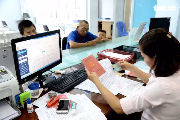 Người dân làm thủ tục hành chính tại phường 4, Q.Tân Bình (TP.HCM) luôn phải kèm theo hộ khẩu và chứng minh nhân dân - Ảnh: TỰ TRUNG