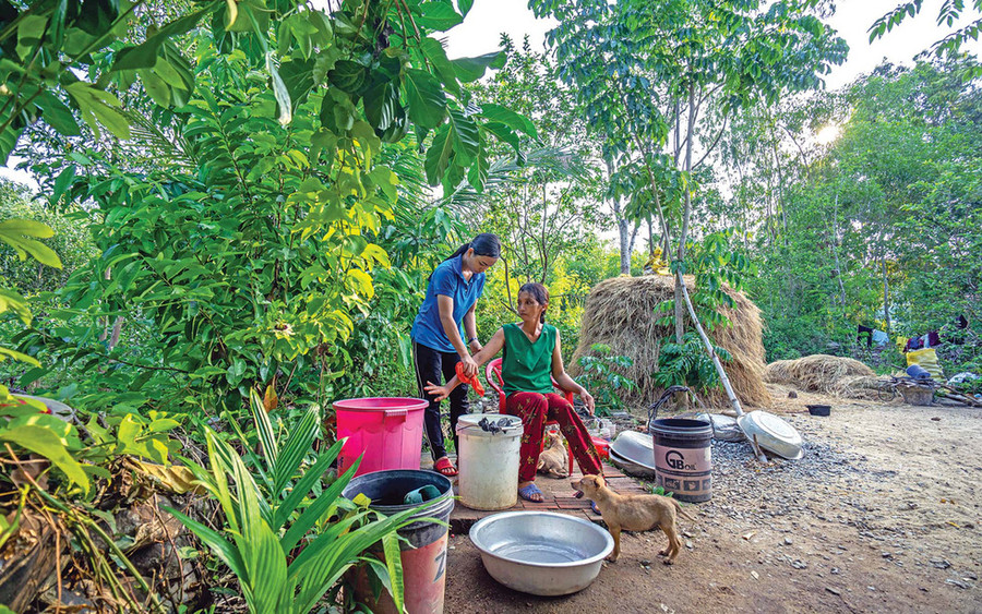 Người chị ngồi yên cho cô lau người