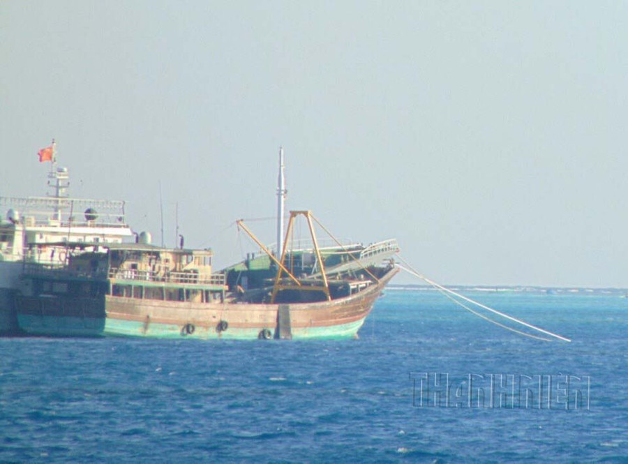 Tàu gỗ (phải) neo cạnh 1 tàu vỏ sắt treo cờ Trung Quốc, trên vùng biển Trường Sa, tháng 12.2013. ẢNH: MAI THANH HẢI