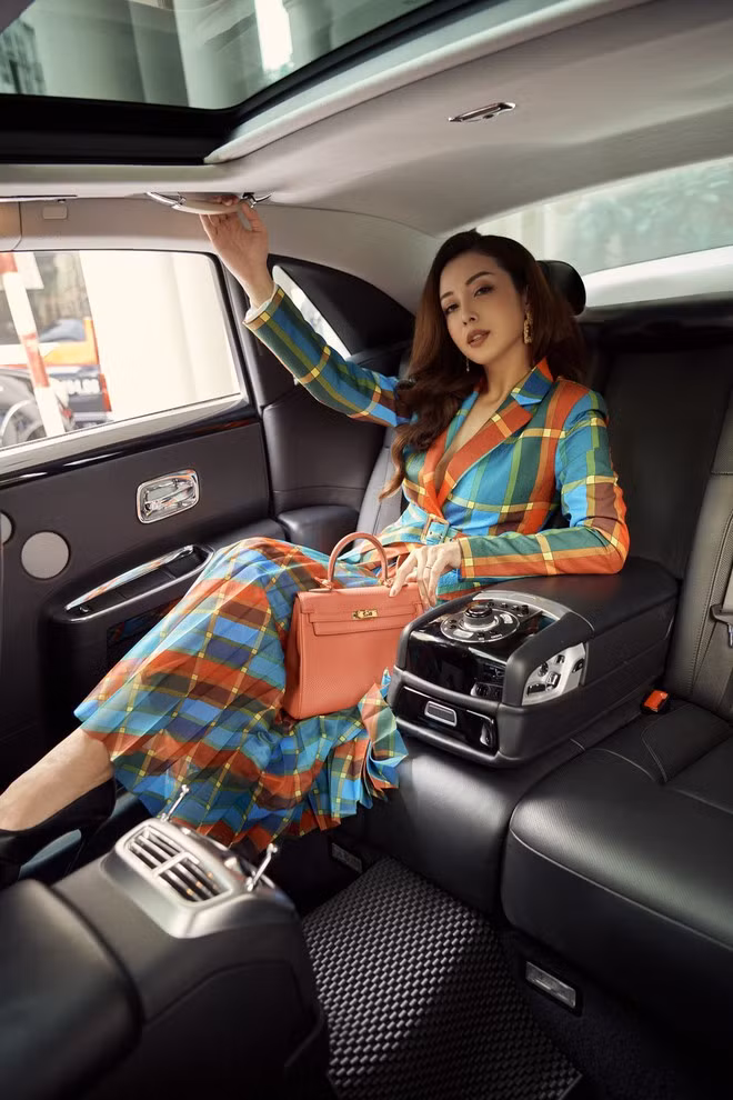 Bên cạnh những trang phục đơn giản, Jennifer Phạm còn thử nghiệm với gam màu tương phản xanh emerald, cam tango, nâu marsal trên nền họa tiết kẻ ô Color Block. Với thiết kế này, Hoa hậu sinh 1985 phối hợp với túi Kelly màu cam của thương hiệu Hermes - một trong những thương hiệu đắt đỏ nhất thế giới. ẢNH: NVCC