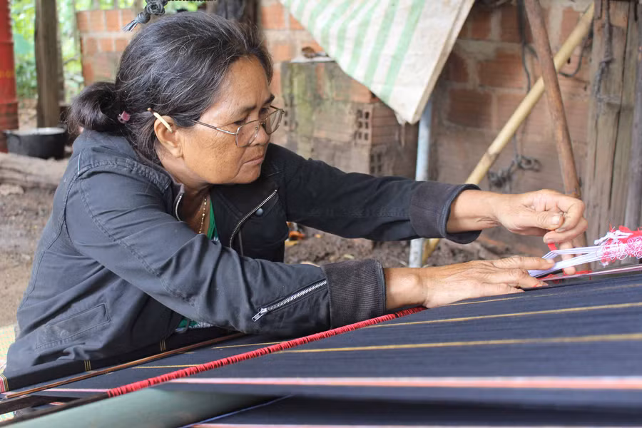 Bà Siu H’Pem (thị trấn Nhơn Hòa, huyện Chư Pưh) bên khung dệt. Ảnh: Nguyễn Giang