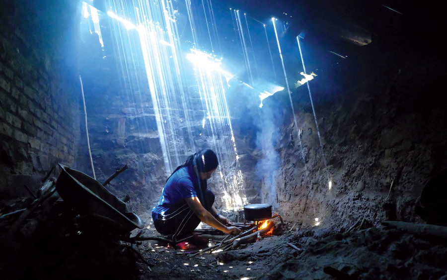 Tùng nấu ăn trong căn bếp đầy lỗ dột. Trong bóng tối vẫn lóe lên ánh sáng hi vọng từ nỗ lực của Tùng