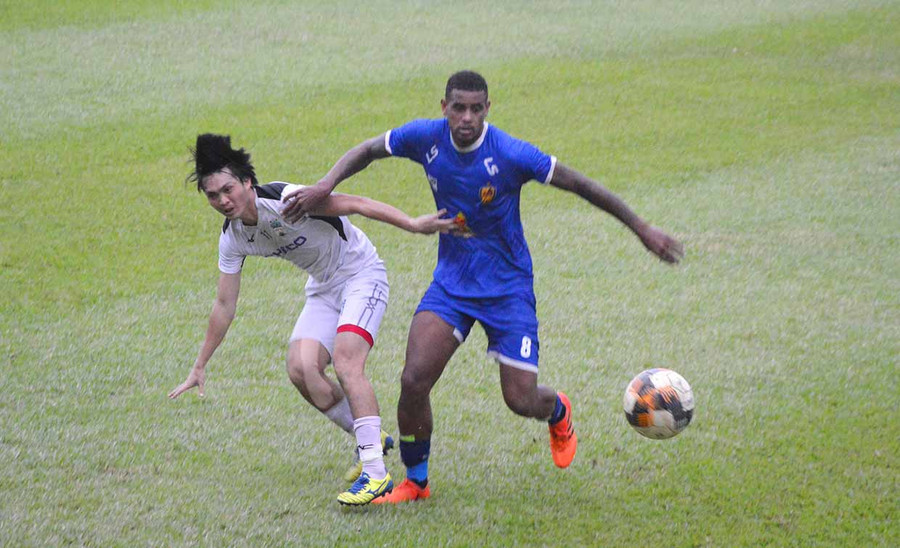  Tiền vệ Nguyễn Tuấn Anh của HA.GL (áo trắng) tranh chấp bóng với ngoại binh đội Quảng Nam. Ảnh: ảnh: Minh Vỹ