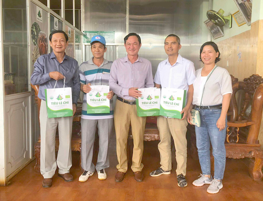 Ông Nguyễn Tấn Công (thứ 2 từ phải sang) tiếp đón khách tham quan, học hỏi kinh nghiệm sản xuất hồ tiêu hữu cơ. Ảnh: Sơn Ca 