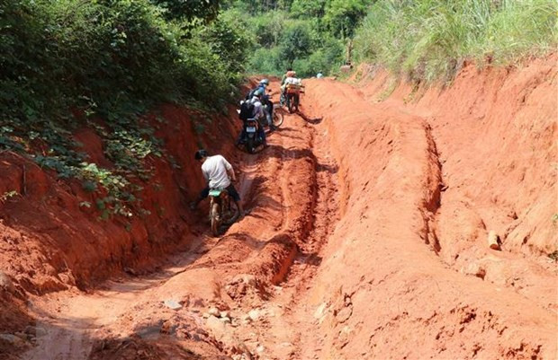 Người dân vất vả di chuyển qua các đoạn đường về làng Đê Kôn. (Ảnh: Hồng Điệp/TTXVN)