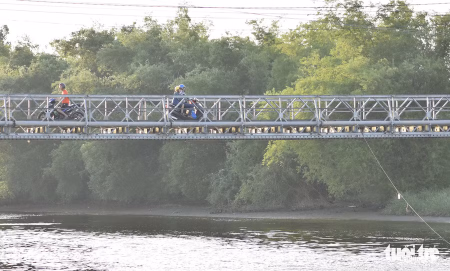 Mẹ con chị Vân qua cầu ở Cẩm Kim, Hội An, hướng về Đà Nẵng