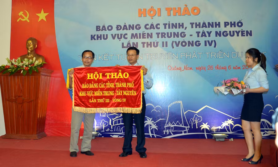 Trao cờ đăng cai Hội thảo cho Báo Kon Tum. Ảnh: Tiến Dũng