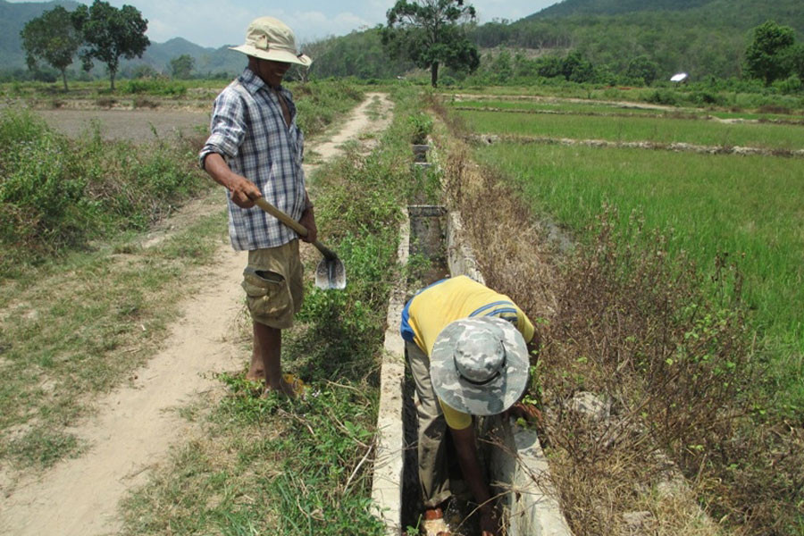 Anh Rơ Lan Thuyết chỉ cho chúng tôi xem những đoạn mương có mực nước thấp hơn ruộng rất nhiều. Ảnh: A.K