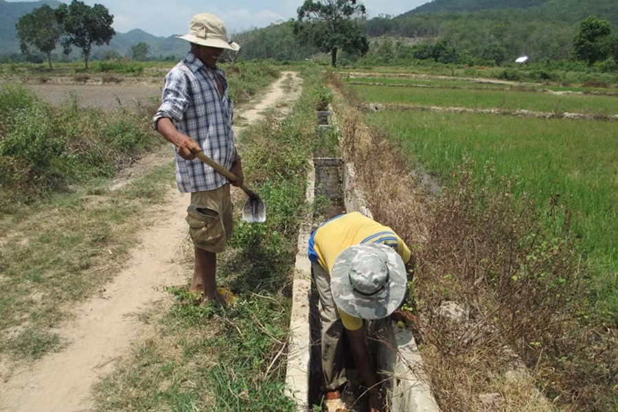 Anh Rơ Lan Thuyết chỉ cho chúng tôi xem những đoạn mương có mực nước thấp hơn ruộng rất nhiều. Ảnh: A.K