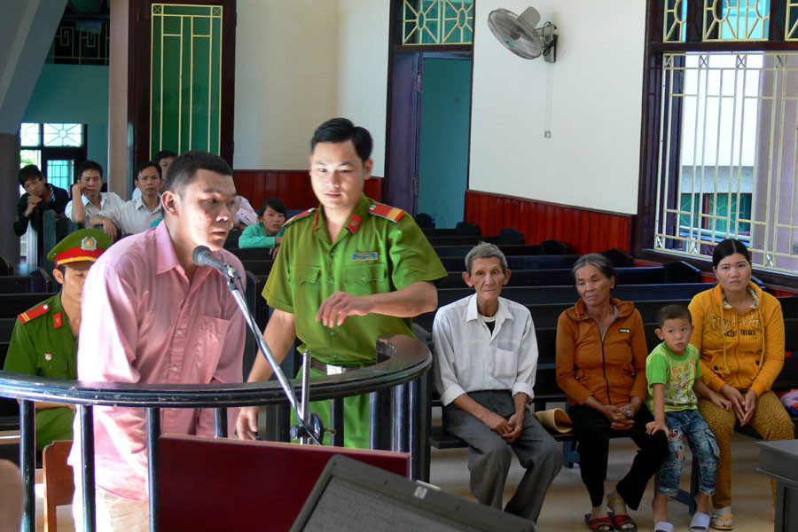 Bị cáo Trần Quang Hiếu trước vành móng ngựa. Ngồi ở hàng ghế phía sau là cha mẹ ruột, vợ và con trai tên Thái của Hiếu. Ảnh: Nguyễn Xuân Bị cáo Trần Quang Hiếu trước vành móng ngựa. Ngồi ở hàng ghế phía sau là cha mẹ ruột, vợ và con trai tên Thái của Hiếu. Ảnh: Nguyễn Xuân