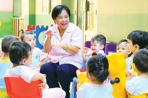 Cô giáo Trần Thị Kim Oanh công tác ở Trường Mầm non 19/5 Thành phố (quận 1) luôn được các trẻ nhỏ yêu thương như bà ngoại ở nhà. Từ bàn tay chăm sóc của cô, biết bao thế hệ học trò đã khôn lớn. Cô tâm sự: “Nghề này vui lắm. Chỉ cần con cầm được ly nước, mang được đôi giày, biết tự ăn là cha mẹ vui mừng một, cô vui đến mười”. Ảnh: HOÀNG HÙNG