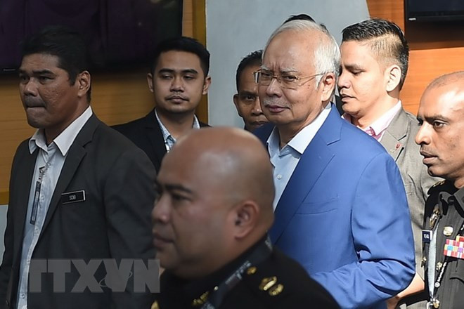 Cảnh sát áp giải cựu Thủ tướng Malaysia Najib Razak (giữa) tới Văn phòng Ủy ban chống tham nhũng ở Putrajaya ngày 22/5. (Ảnh: THX/TTXVN)