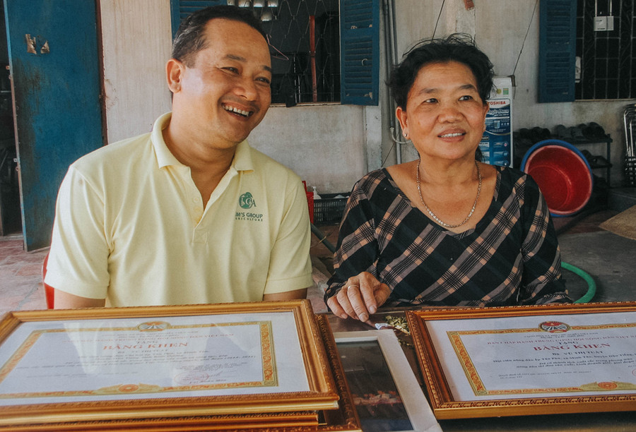 Bà Tuất (phải) hào hứng khoe những bằng khen giấy khen