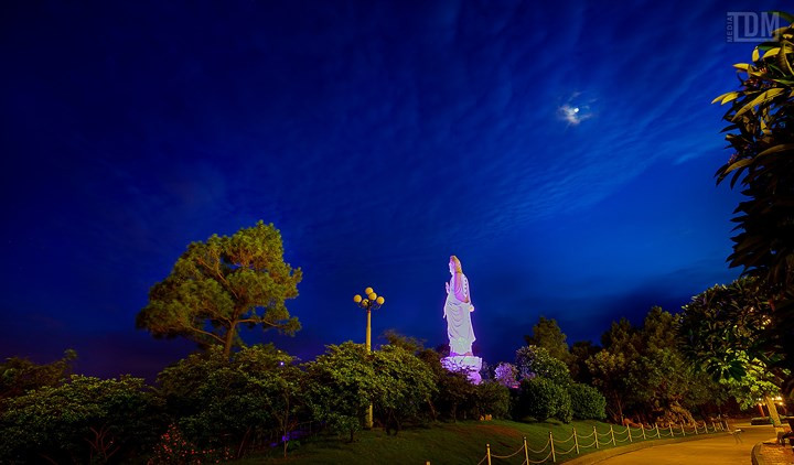  Bức tượng Quan Thế Âm Bồ tát bằng đá trắng uy nghi nhìn xuống phía cổng tam quan vào chùa. Từ đây có thể nhìn xuống thấy toàn bộ thành phố Uông Bí phía xa.