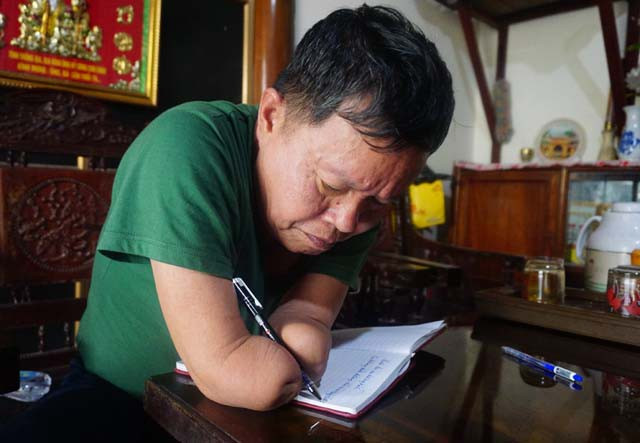 Không còn bàn tay để cầm bút, ông 