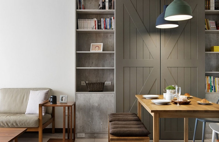 Bàn ăn gỗ đặt giữa khu vực tiếp khách và bếp nấu.