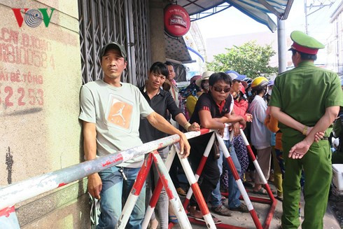  Người dân Phan Thiết đứng đầu đường Nguyễn Văn Trỗi xem xe chở các đối tượng ra khỏi tòa.