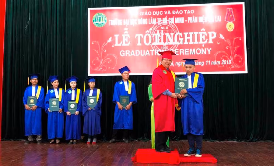 Tiến sĩ Trần Đình Lý (áo đỏ) trao bằng tốt nghiệp cho các sinh viên. Ảnh: Phan Lài