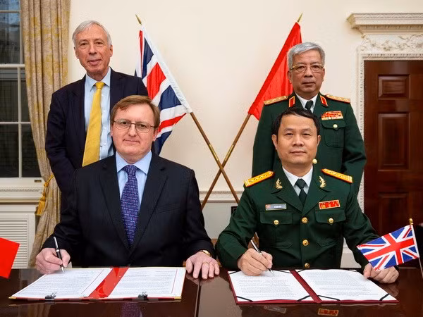 Thượng tướng Nguyễn Chí Vịnh, Ủy viên Trung ương Đảng, Thứ trưởng Bộ Quốc phòng và Quốc vụ khanh Bộ Quốc phòng Anh, Bá tước Howe (ông Frederick Curzon) (đứng hàng sau) chứng kiến lễ ký Biên bản ghi nhớ về hợp tác giữa Cục Bản đồ, Bộ Tổng tham mưu Quân đội Nhân dân Việt Nam, và Trung tâm Địa lý Quốc phòng Anh ngày 28/11/2018. (Ảnh: Tuấn Anh/TTXVN)