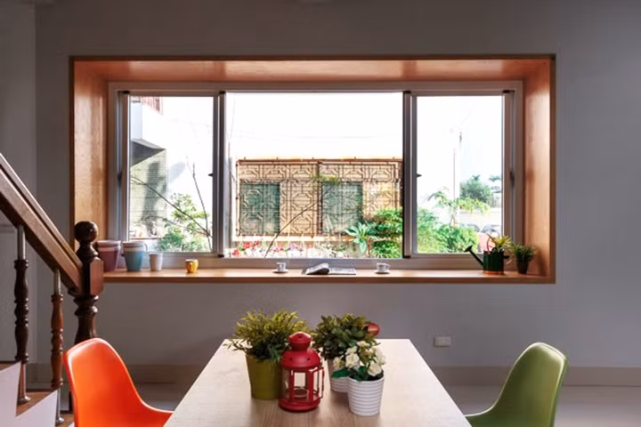 Khung cửa sổ bằng sắt cũ được thay thế bằng bậu cửa gỗ có thể làm bàn uống nước, đọc sách. 7 Từ phòng ăn các thành viên cũng có thể di chuyển ra vườn thông qua cửa kính ở cuối phòng.