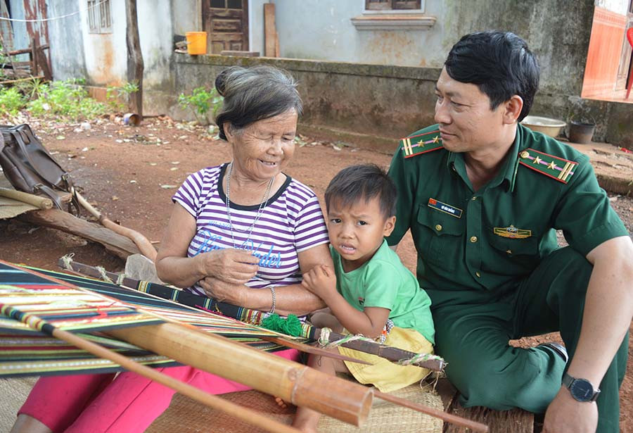 Trung tá Vũ Văn Hoằng trò chuyện với bà Rơ mah hBlup. Ảnh: P.D