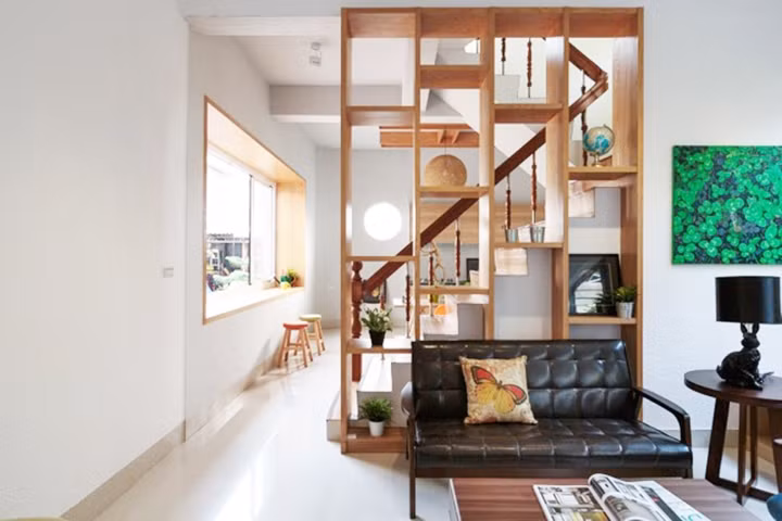 Kệ trang trí đồng thời cũng là vách ngăn giữa phòng khách và nhà bếp.