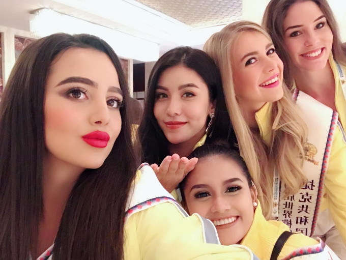 Ngọc Huyền (giơ tay) khoe nhan sắc bên cạnh các thí sinh nước bạn.