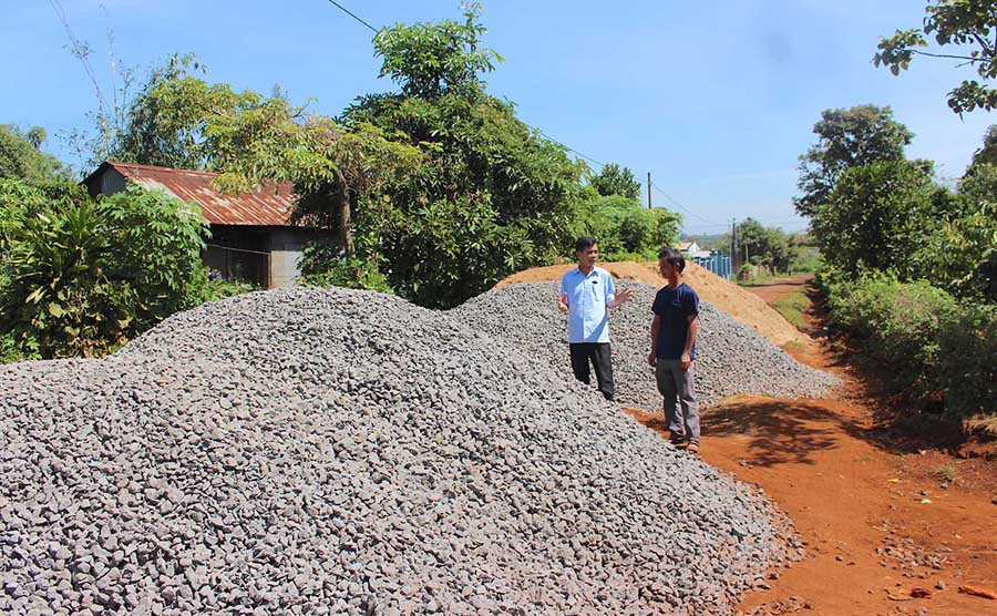  Người dân làng Brọch 1 (xã A Dơk) tập kết vật liệu để chuẩn bị đổ bê tông cho con đường làng. Ảnh: H.T