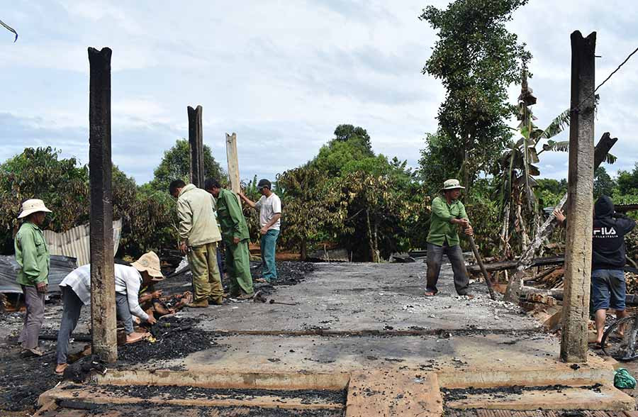 Người dân đang giúp đỡ gia đình ông Mil dọn dẹp sau vụ cháy.Ảnh: Phan Thương