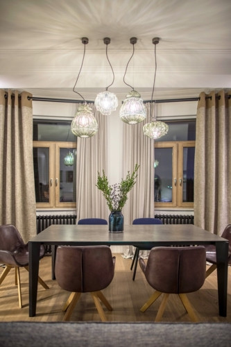 Đèn mặt dây chuyền có chụp đèn làm bằng thủy tinh chiếu sáng khu vực quan trọng trong phòng ăn, bình hoa màu xanh phản chiếu ánh sáng từ đèn thêm cảm giác sang trọng vào không gian. Đèn mặt dây chuyền có chụp đèn làm bằng thủy tinh chiếu sáng khu vực quan trọng trong phòng ăn, bình hoa màu xanh phản chiếu ánh sáng từ đèn thêm cảm giác sang trọng vào không gian.