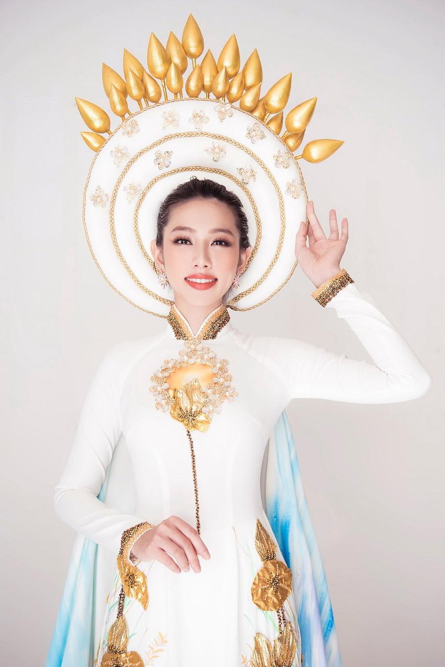 Cùng chiếc mấn lấy chủ đề hoa sen, nhà thiết kế Việt Hùng chia sẻ, hoa sen vàng chiếu sáng lung linh được những người thợ thủ công cần mẫn đắp nối tạo hiệu ứng 3D cùng hàng trăm hạt pha lê đính kết tỉ mỉ. (Ảnh: Mon Trần) Cùng chiếc mấn lấy chủ đề hoa sen, nhà thiết kế Việt Hùng chia sẻ, hoa sen vàng chiếu sáng lung linh được những người thợ thủ công cần mẫn đắp nối tạo hiệu ứng 3D cùng hàng trăm hạt pha lê đính kết tỉ mỉ. (Ảnh: Mon Trần)