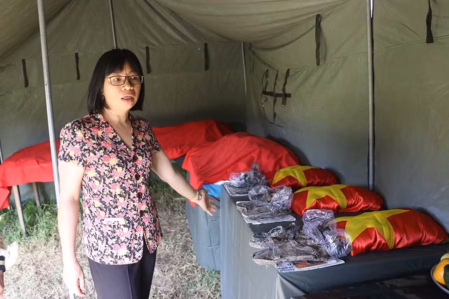  Bà Nguyễn Thị Thanh Lịch-Bí thư Thị ủy An Khê-bên các hài cốt liệt sĩ được cất bốc. Ảnh: N.M