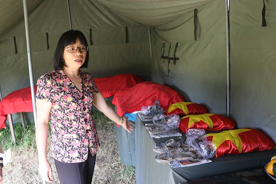  Bà Nguyễn Thị Thanh Lịch-Bí thư Thị ủy An Khê-bên các hài cốt liệt sĩ được cất bốc. Ảnh: N.M