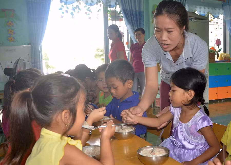 Cô giáo Lê Thị Hồng, Trường Mầm non Họa Mi xã Ia Tul đưa cơm đến điểm trường thôn Blanh cho học trò ăn trưa. Ảnh: Đức Phương