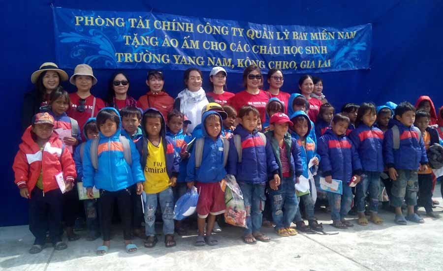 Tặng áo ấm và vở cho các em học sinh. Ảnh: Hồng Ngọc 