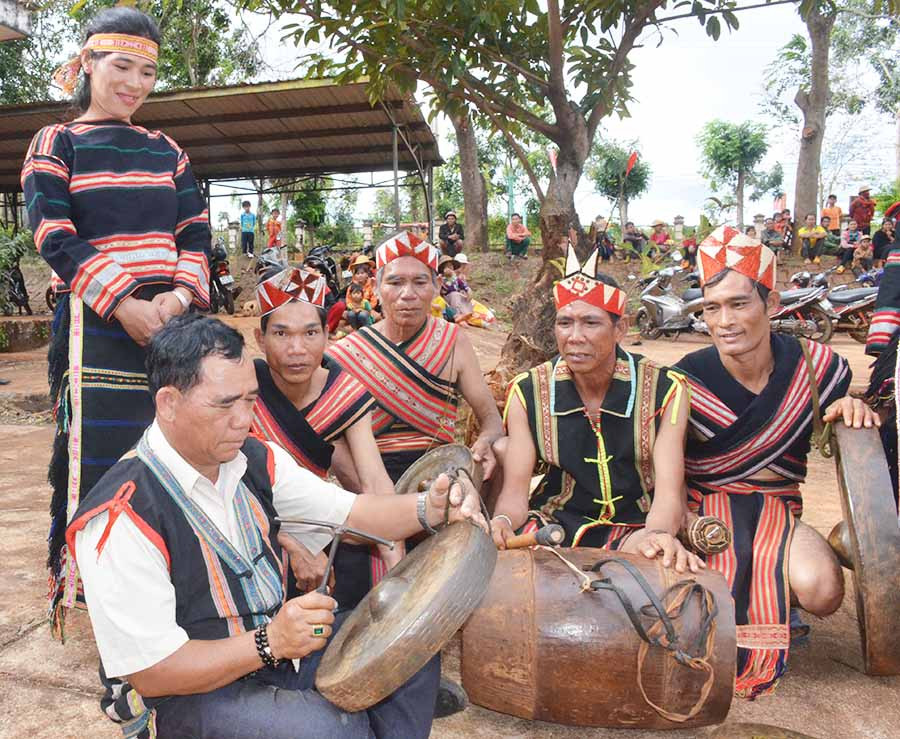  Ông Rơ Châm Luih (người ngồi ở bìa trái) đang chỉnh chiêng. Ảnh: T.T