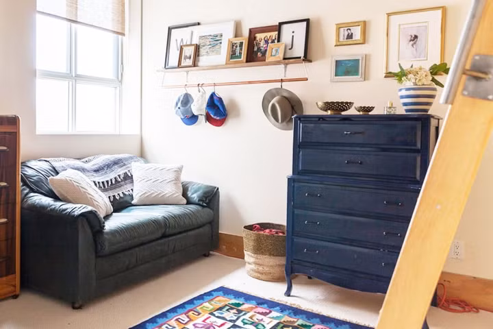 Khu vực dẫn lên gác lửng đặt một chiếc ghế sofa làm nơi thư giãn, đây cũng là nơi lưu giữ những bức ảnh gia đình và những đồ vật mang tính kỷ niệm của các thành viên trong nhà. 