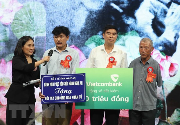 Các nhà tài trợ tặng quà cho nông dân Hoa Xuân Tứ (bên phải), người bị mất cả hai cánh tay từ nhỏ, một tấm gương vượt khó tiêu biểu đã được gặp Bác Hồ năm 1966. (Ảnh: Thống Nhất/TTXVN) Các nhà tài trợ tặng quà cho nông dân Hoa Xuân Tứ (bên phải), người bị mất cả hai cánh tay từ nhỏ, một tấm gương vượt khó tiêu biểu đã được gặp Bác Hồ năm 1966. (Ảnh: Thống Nhất/TTXVN)