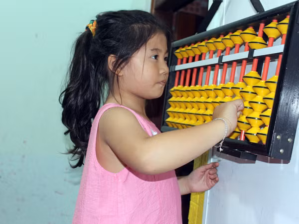 Trẻ luyện tập tính toán bằng bàn tính cổ soroban tại Smart Kids Gia Lai. Ảnh: N.G