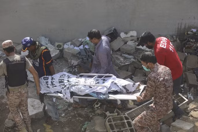 Thi thể nạn nhân được đưa ra ngoài. Ảnh: AP