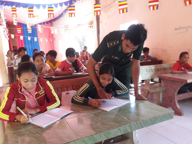 Trung úy Danh Hải dạy chữ Khmer cho trẻ em địa phương. ẢNH: NGUYỄN ĐÌNH THÀNH