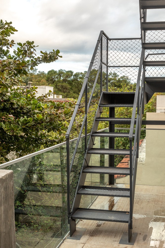 Cầu thang bằng thép dẫn lên sân thượng, nơi các thành viên có thể thu trọn khung cảnh thành phố vào trong tầm mắt.